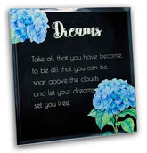 Decorative plaque with blue flowers and motivational quote about dreams on a black background
